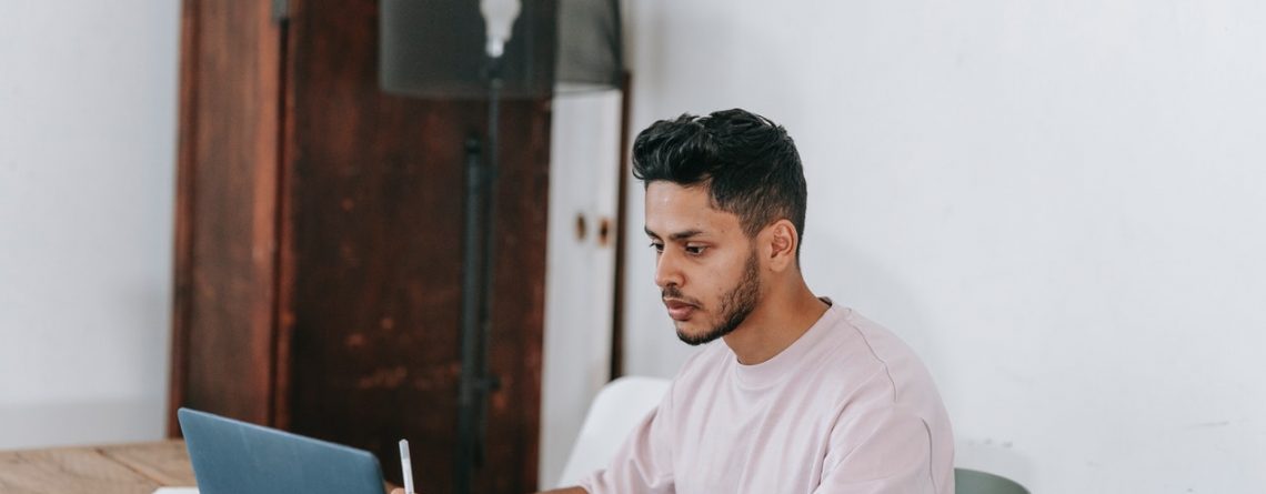 man at his computer works on getting late invoices paid