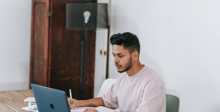 man at his computer works on getting late invoices paid