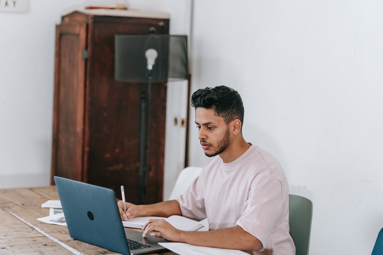 man at his computer works on getting late invoices paid