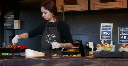 Woman working the till at a cafe